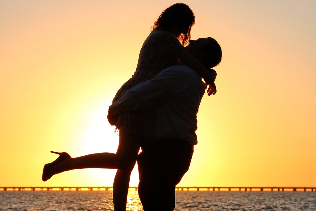 Silhouette of a couple embracing with a sunset in the background