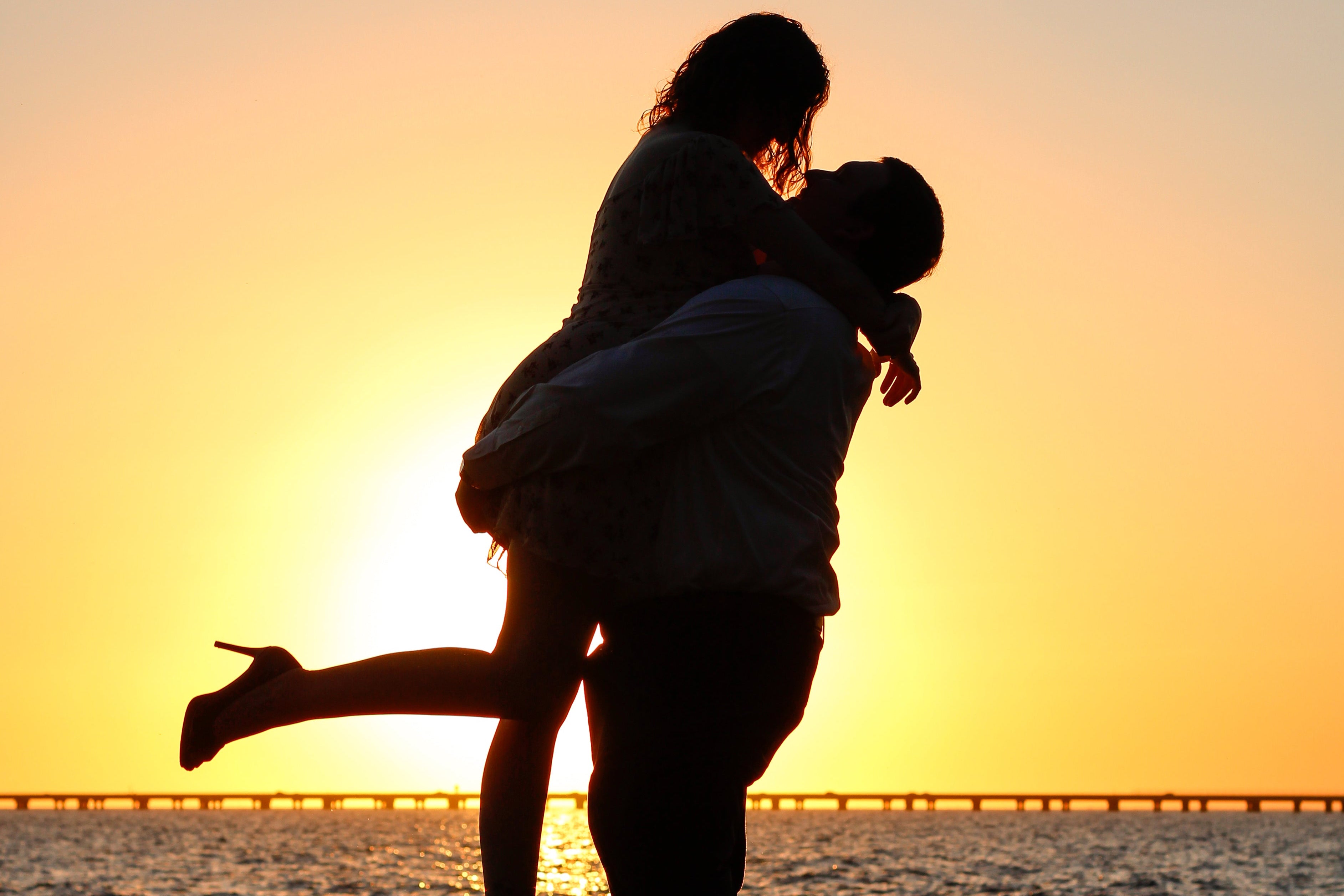 Silhouette of a couple embracing with a sunset in the background